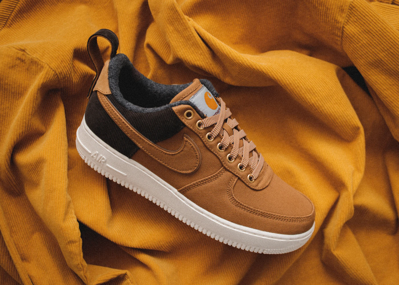 Brown lace-up sneakers resting on mustard-colored fabric