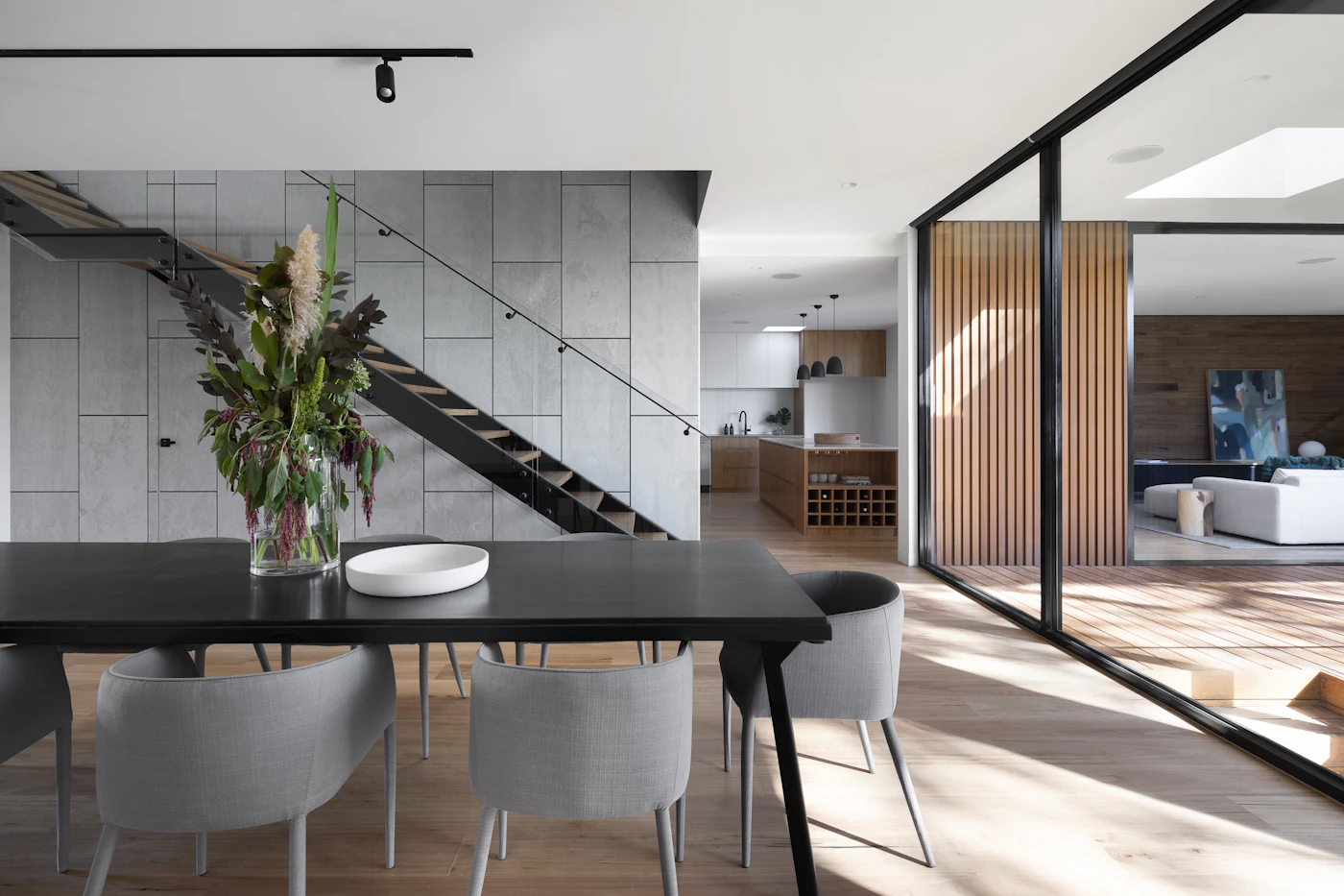 Open-plan interior with a dining table, staircase and clear circulation space