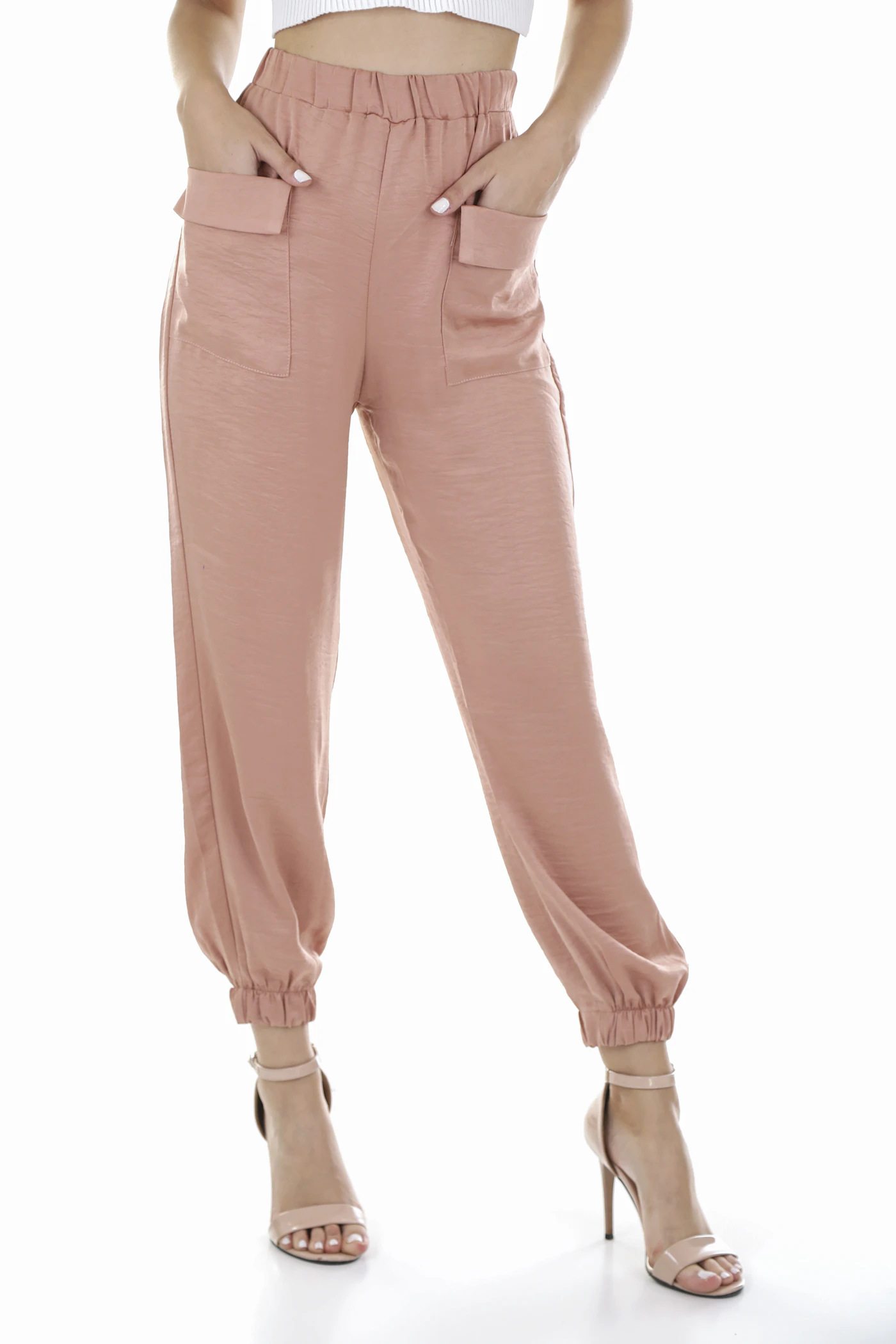Neutral trousers styled with a light top in natural daylight