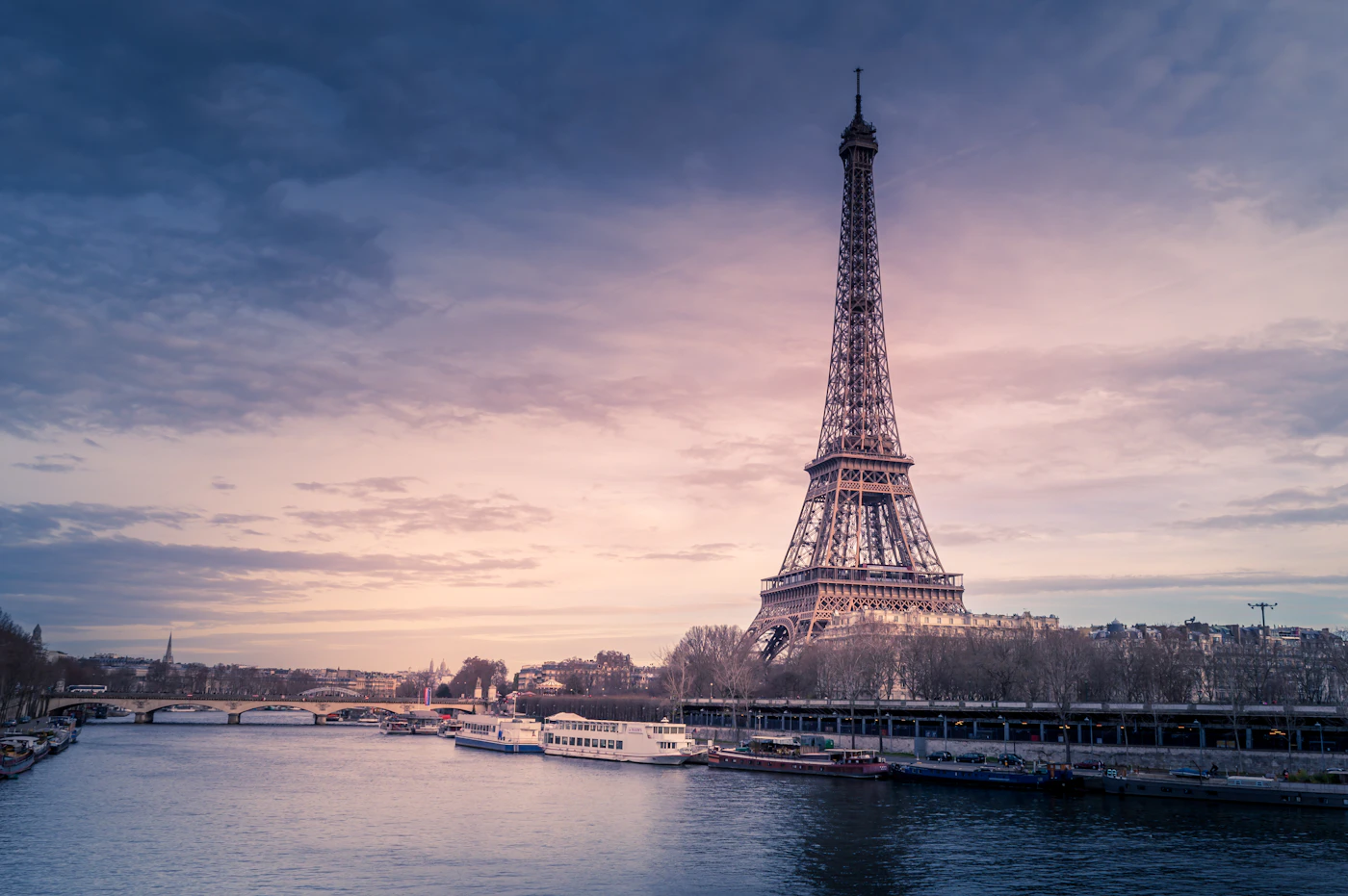 Eiffel Tower and Paris rooftops beneath a pink evening sky